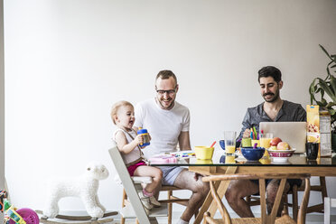 Väter spielen mit ihrer Tochter, während sie am Tisch an der Wand frühstücken - CAVF44292
