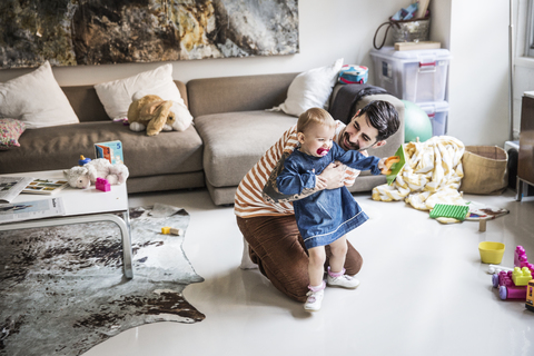 Vater und Tochter spielen im heimischen Wohnzimmer, lizenzfreies Stockfoto