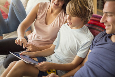 Blick von oben auf eine Familie mit Tablet-Computer auf dem Sofa - CAVF44405