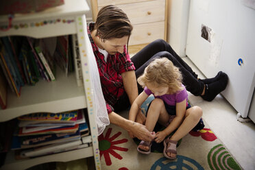 High angle view of father wearing shoes to daughter - CAVF44423