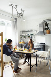 Eltern mit Sohn beim Frühstück am Tisch in der Küche - CAVF44467