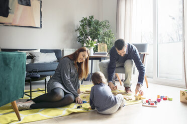 Parents and son playing with toys at home - CAVF44479