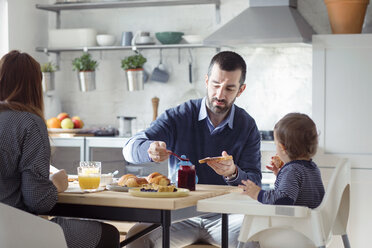 Familie beim Frühstück in der Küche zu Hause - CAVF44483