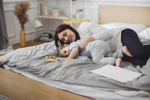 Glückliche Mutter liegt mit ihrem kleinen Jungen im Bett zu Hause - CAVF44546