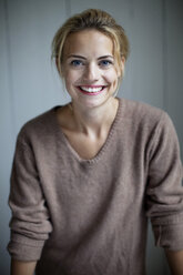Porträt einer glücklichen jungen Frau im Pullover, die lächelt - MASF06067