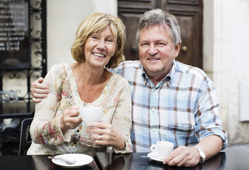 Porträt eines glücklichen Paares beim Kaffee trinken am Tisch - MASF06077