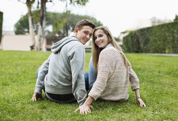 Porträt eines glücklichen jungen Paares, das zusammen im Park sitzt - MASF06094