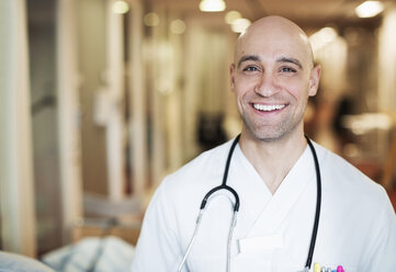 Porträt eines glücklichen erwachsenen männlichen Arztes im Krankenhaus - MASF06122