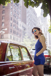 Fashionable woman standing near vintage car - CAVF44767