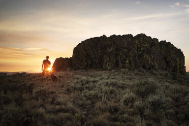 Silhouette Mann auf grasbewachsenem Feld gegen den Himmel im Badlands National Park - CAVF44772