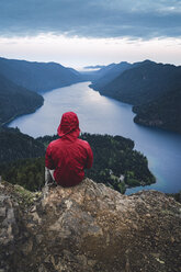 Rear view of hiker sitting on cliff at Olympic National Park - CAVF44786