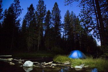 Zelt am Flussufer gegen Bäume in der Abenddämmerung - CAVF44807