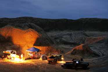 A light painting of a woman doing yoga next to her tent and