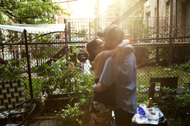 Zärtliches Paar, das sich küsst, während es im Hof steht - CAVF44942