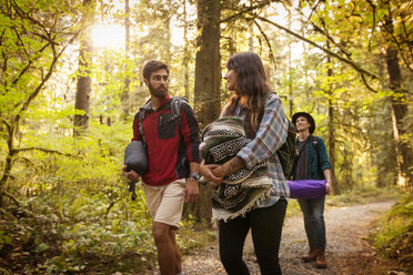 Freunde unterhalten sich beim Spaziergang im Wald - CAVF44950