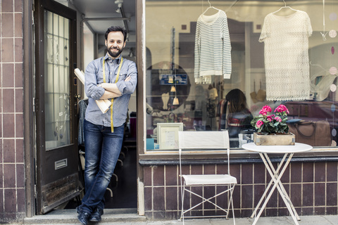 Portrait of confident mid adult male designer standing at studio entrance stock photo