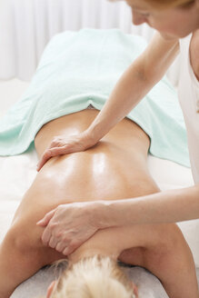 Reife Masseurin gibt eine Rückenmassage an weiblichen Kunden im Wellnessbereich - MASF06209
