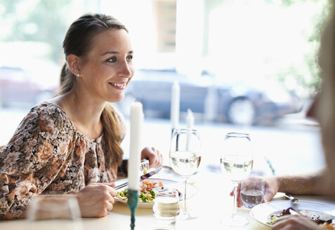 Glückliche junge Frau, die einen Freund am Restauranttisch ansieht - MASF06272