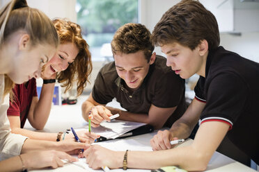 Glückliche junge Studenten beim gemeinsamen Lernen am Tisch - MASF06296