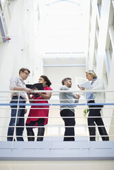 Low angle view of business people discussing by railing - MASF06302