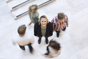 High angle view of happy mature businesswoman surrounded by colleagues - MASF06305