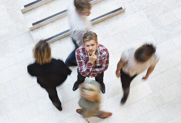 High angle view of thoughtful businessman with colleagues walking around - MASF06306