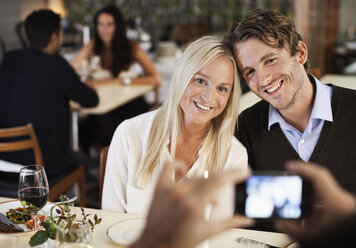 Happy friends posing for photograph in restaurant - MASF06339