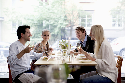 Group of happy friends at restaurant table stock photo