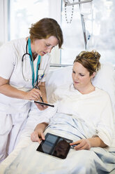 Eine Ärztin zeigt einem Patienten auf der Krankenstation Notizen - MASF06461