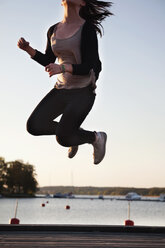 Teenager-Mädchen genießt die Freiheit, indem sie auf den Steg springt - MASF06474