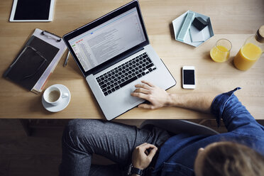 High angle view of man using laptop computer while sitting at table - CAVF45026