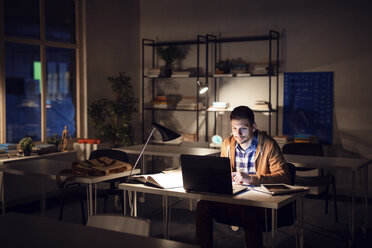 Confident student studying in library at night - CAVF45039