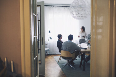 Geschäftsleute diskutieren im Büro durch die Tür gesehen - CAVF45056