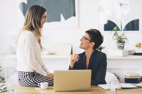 Happy businesswomen talking in office - CAVF45066