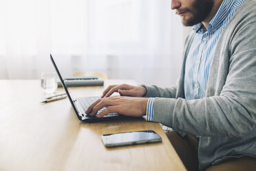 Midsection of businessman using laptop computer at desk - CAVF45073