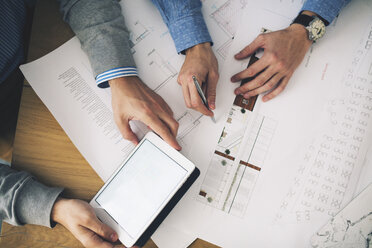 Cropped image of businessmen analyzing blueprints in office - CAVF45090