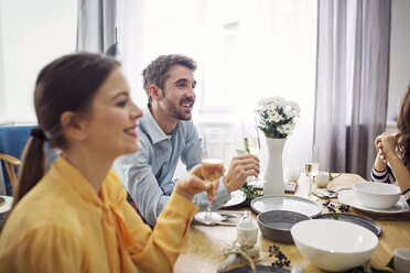 Happy friends drinking champagne at table in party - CAVF45104