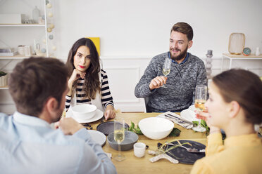 Friends discussing while sitting at table in lunch party - CAVF45105