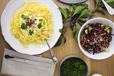 Overhead view of spaghetti pasta with salad served on table - CAVF45116