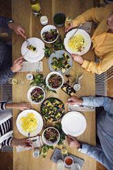 Overhead view of friends eating lunch while sitting at dinning table in party - CAVF45119