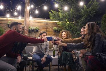 Happy friends toasting drinks in party at backyard - CAVF45199