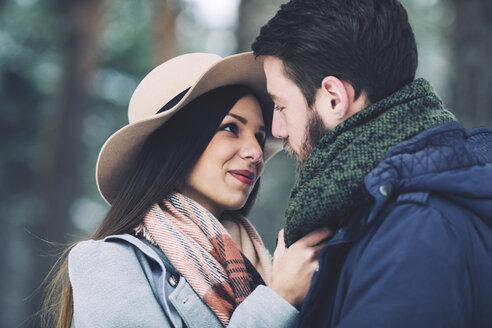 Nahaufnahme eines romantischen Paares, das sich im Winter im Wald ansieht - CAVF45235