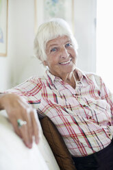 Porträt einer lächelnden älteren Frau auf dem Sofa - MASF06512