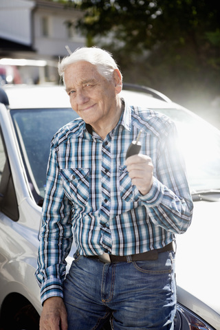 Porträt eines lächelnden älteren Mannes mit Autoschlüssel, lizenzfreies Stockfoto