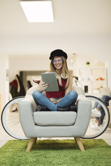 Casual young woman using tablet in coworking space - OCAF00214