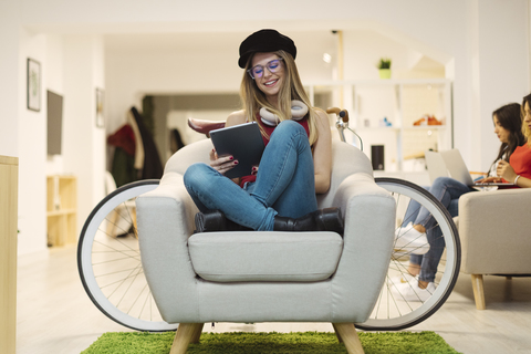 Casual young woman using tablet in coworking space stock photo