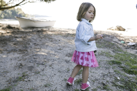 Little girl standing on the beach stock photo