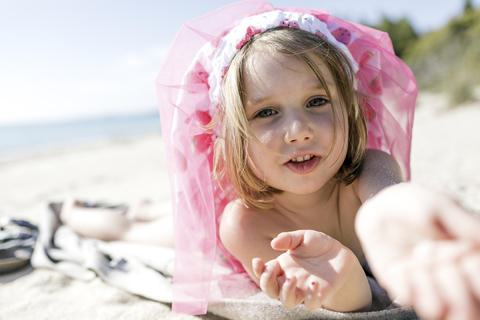 Porträt eines kleinen Mädchens, das am Strand liegt, lizenzfreies Stockfoto