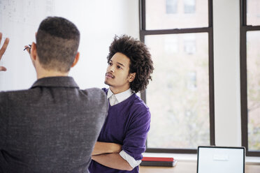 Businessmen discussing over chart in creative office - CAVF45320