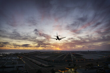 Silhouette eines landenden Flugzeugs auf einem Flughafen - CAVF45344